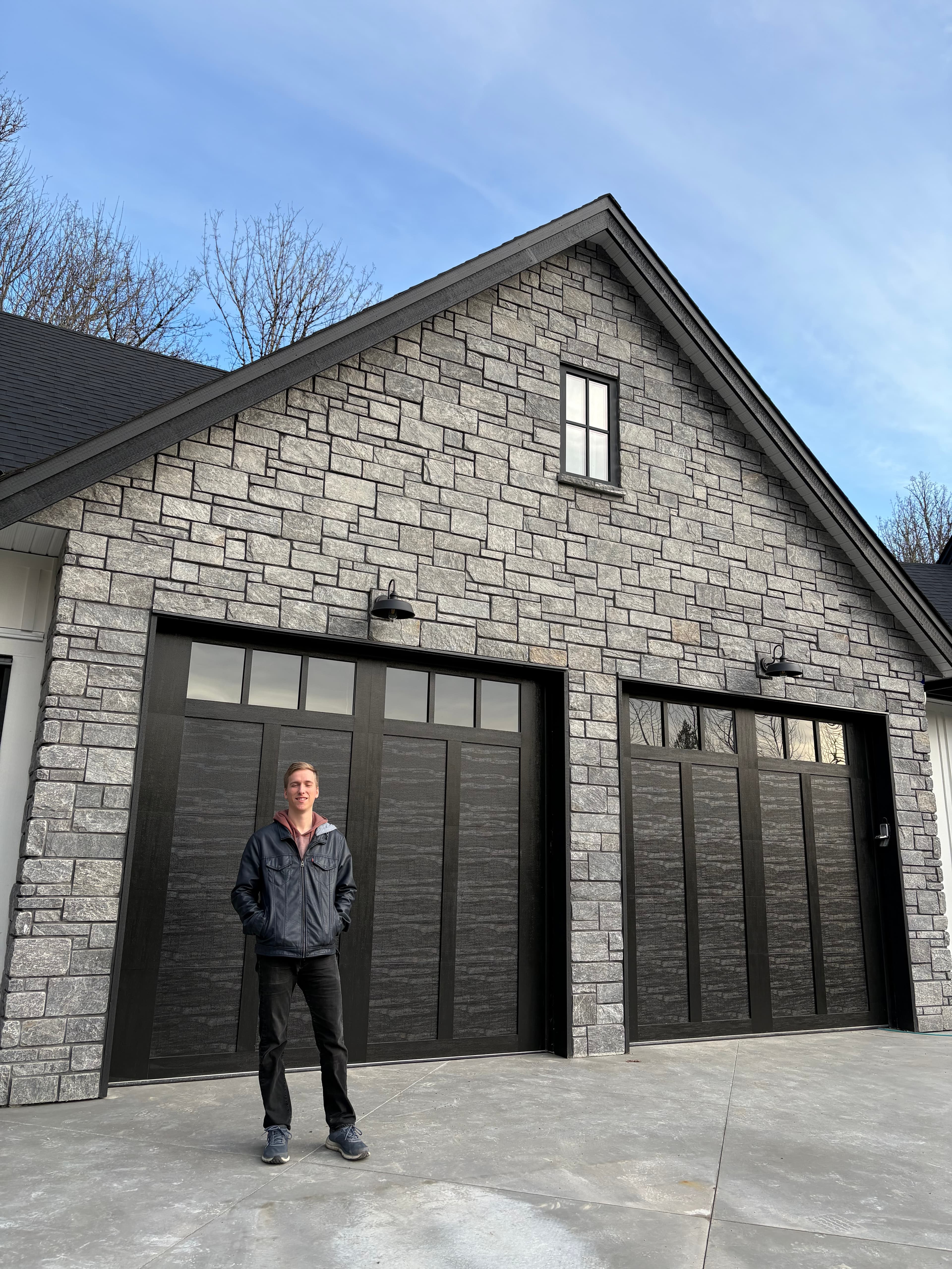 Grey stone veneer garage facade with stacked stone detailing