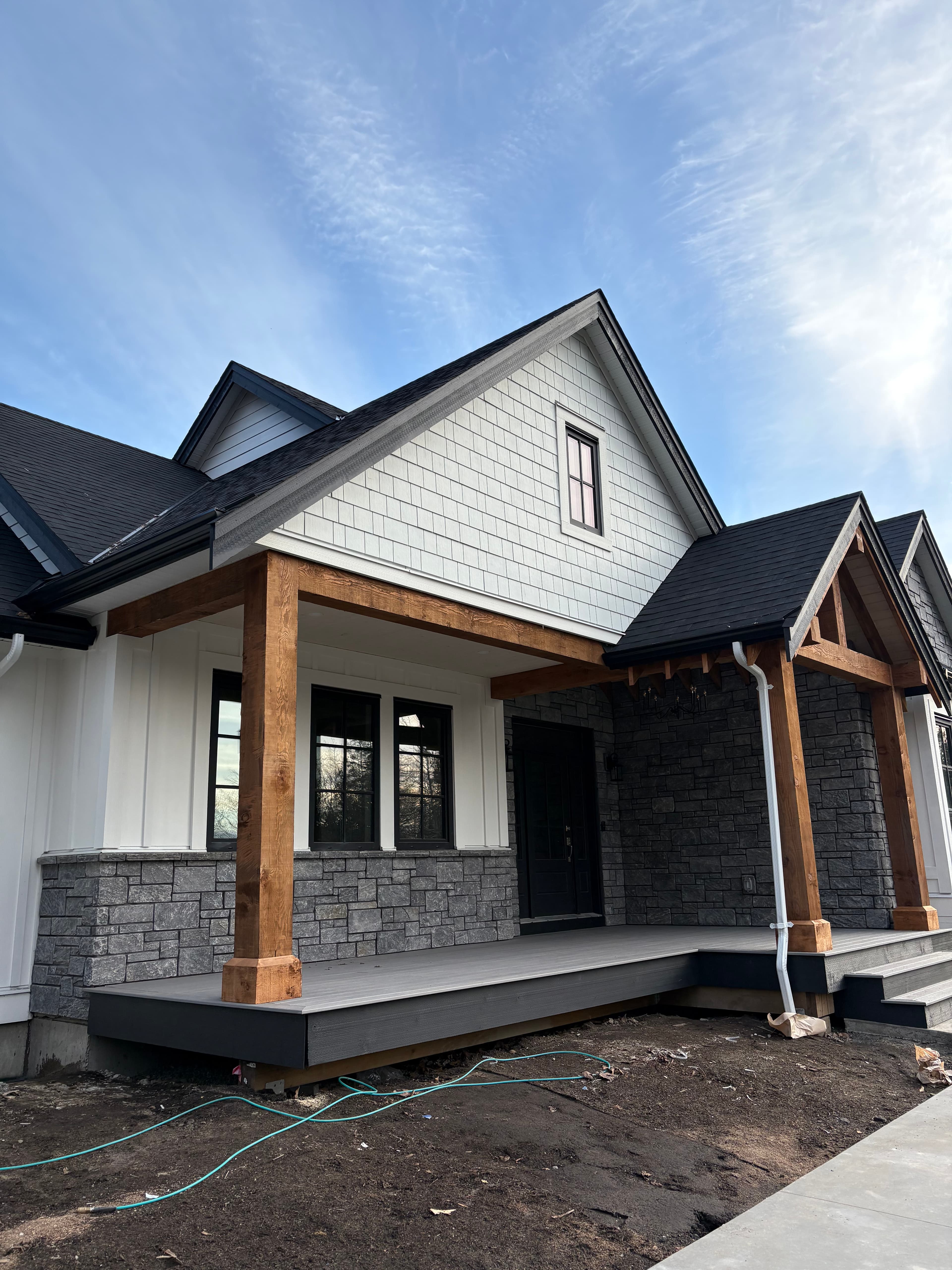 Grey stone veneer wainscot and stone base on a home front porch