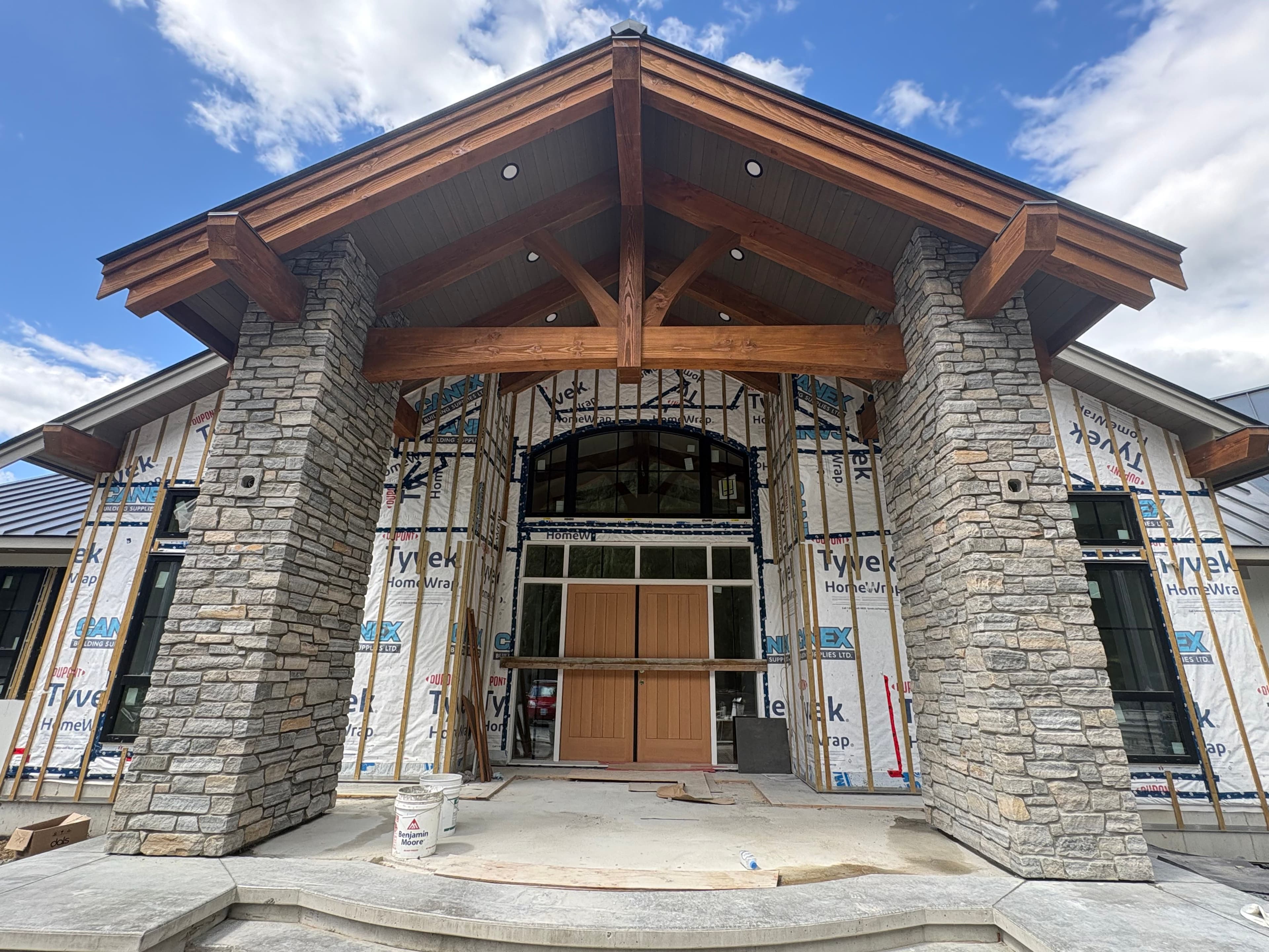 Natural stone veneer columns flanking a timber-framed grand entrance