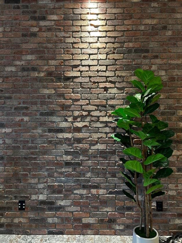 Reclaimed red brick interior feature wall with accent lighting